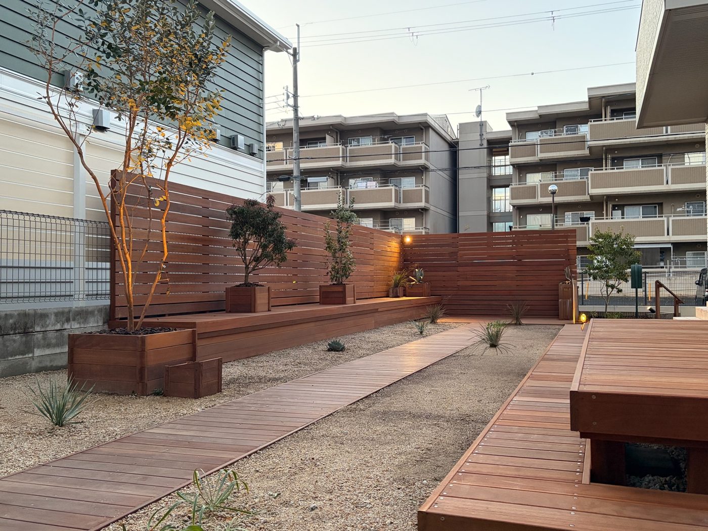 異なる高さの床と棚、植栽、園路を組み合わせた庭