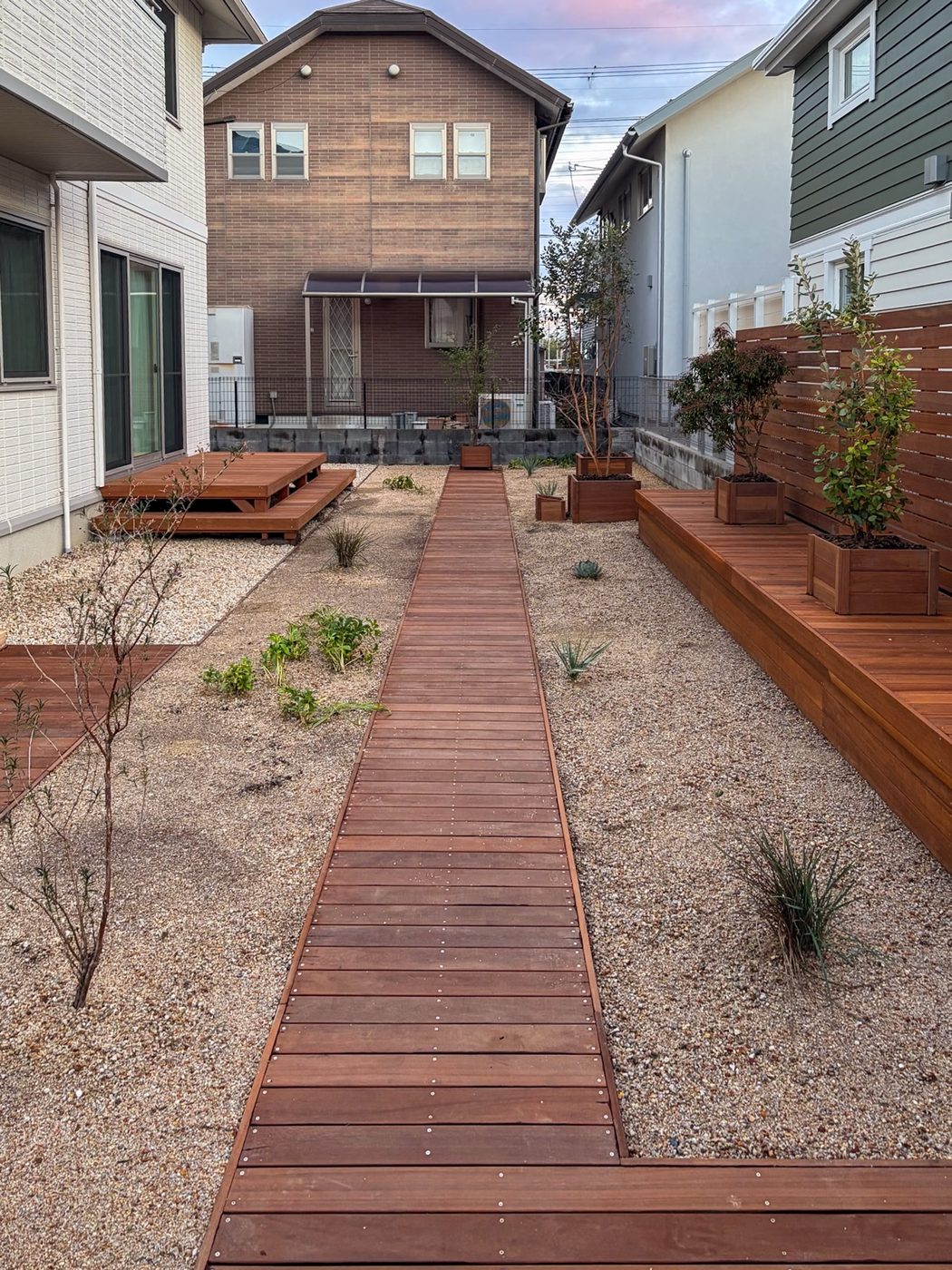 庭を通る木の園路と、植物を並べられる棚状の床。